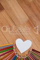 Colored pencil arranged around heart shape paper