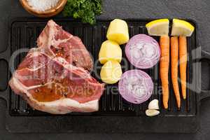 Sirloin chop and ingredients on black grill