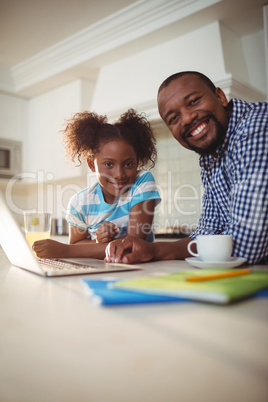 Portrait of father and daughter with laptop