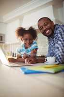 Portrait of father and daughter with laptop