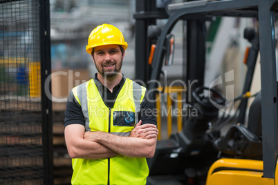 Factory worker standing with arms crossed in factory