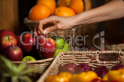 Hand of female staff holding apples in organic section