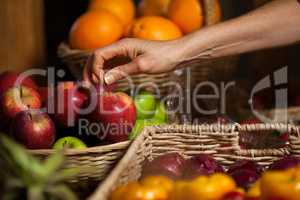 Hand of female staff holding apples in organic section