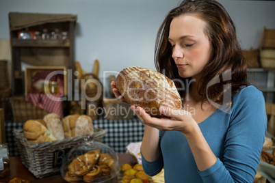 Woman smelling bread at bakery counter