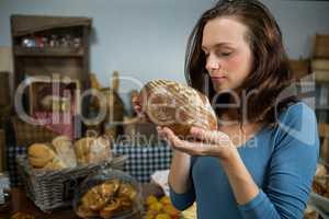 Woman smelling bread at bakery counter