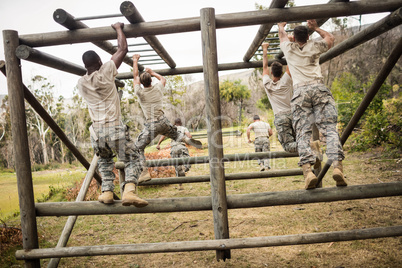 Soldiers climbing monkey bars