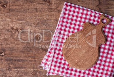 Empty kitchen board for cutting on a brown wooden surface