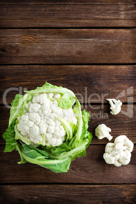 Fresh whole cauliflower on wooden rustic background, top view