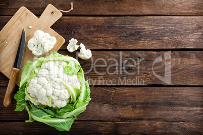 Fresh whole cauliflower on wooden rustic background, top view