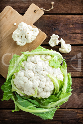 Fresh whole cauliflower on wooden rustic background, top view