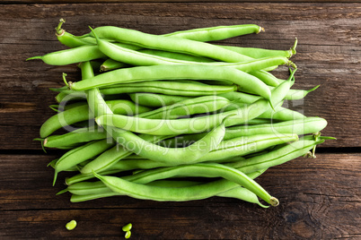 Fresh green beans on dark wooden rustic background top view flat lay