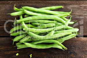 Fresh green beans on dark wooden rustic background top view flat lay