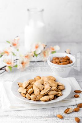 Almond nuts and milk on white background