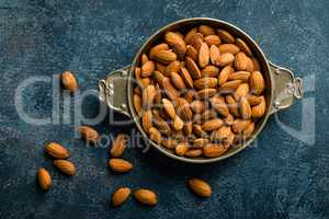 Almond nuts on dark background directly above copy space flat lay