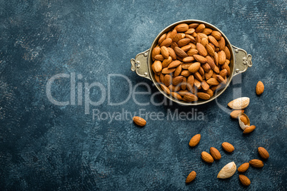 Almond nuts on dark background directly above copy space flat lay