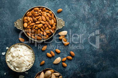 Almond nuts on dark background directly above copy space flat lay