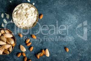 Almond nuts on dark background directly above copy space flat lay