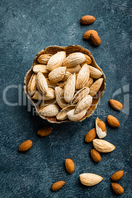 Almond nuts on dark background directly above copy space flat lay