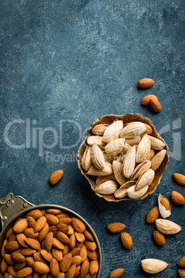 Almond nuts on dark background directly above copy space flat lay