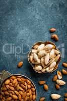 Almond nuts on dark background directly above copy space flat lay