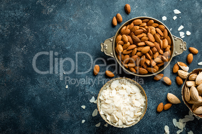 Almond nuts on dark background directly above copy space flat lay