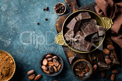 Dark chocolate pieces crushed and cocoa beans, culinary background, top view