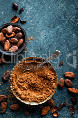 Cocoa powder and cacao beans on dark background, top view