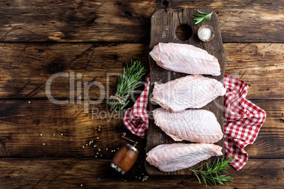 Raw turkey wings on wooden background top view, copy space, flat lay