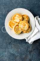 Frying homemade cottage cheese pancakes, syrniki on white plate