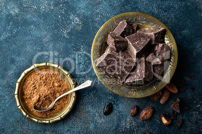 Dark chocolate pieces crushed and cocoa beans, culinary background, directly above