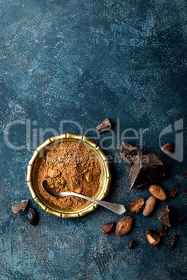 Cocoa powder, beans and dark chocolate pieces crushed, culinary background, top view