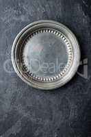 Empty metal plate on dark texture background top view, copy space
