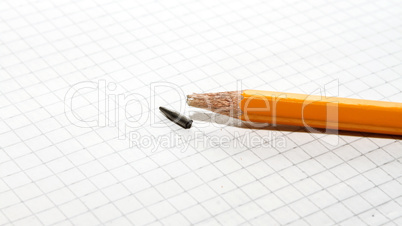 Broken pencil on checkered paper