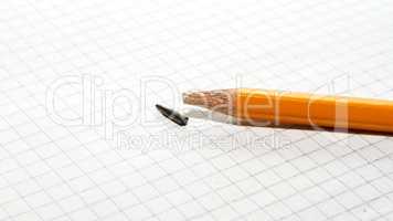 Broken pencil on checkered paper