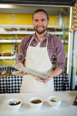 Portrait of smiling male staff working at meat counter