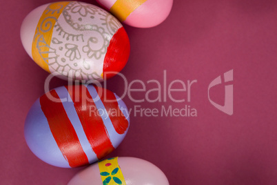 Various Easter eggs arranged on pink background