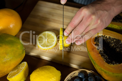 Staff slicing lemon on chopping board