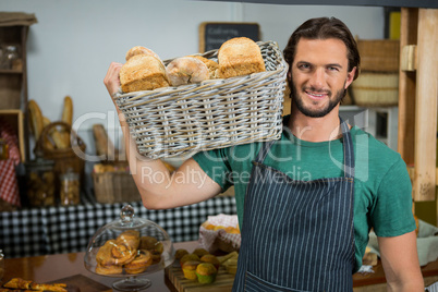 Portrait of male staff holding a basket of bread