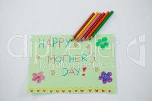Color pencil kept on happy mothers day greetings card