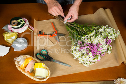 Male florist preparing a flower bouquet