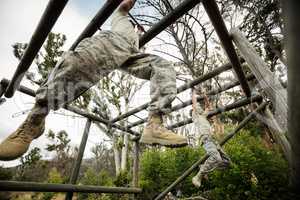 Soldiers climbing monkey bars
