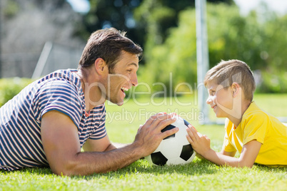 Father and son lying on grass in the park