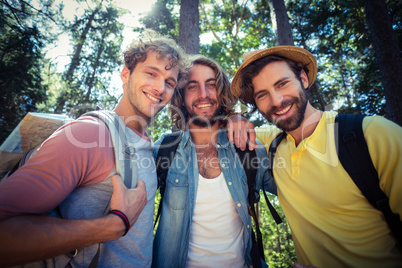 Male friends standing together in forest