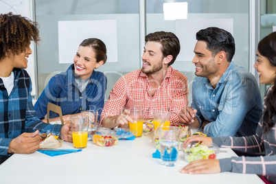 Happy executives interacting while having breakfast