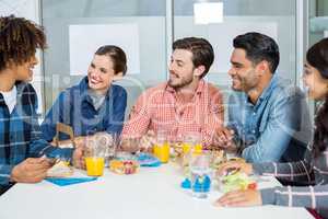 Happy executives interacting while having breakfast