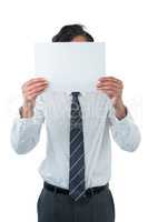 Business executive covering his face behind blank paper