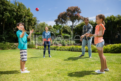 Happy family playing with the ball in park