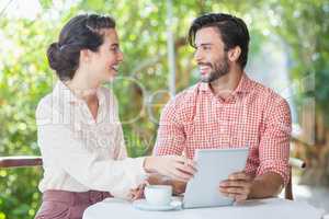 Couple smiling while using digital tablet
