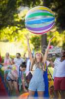 Woman playing with beach ball at campsite