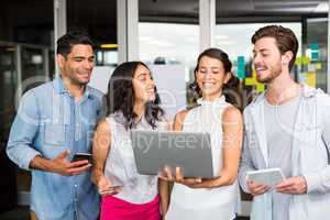 Happy executives using laptop, digital tablet and mobile phone